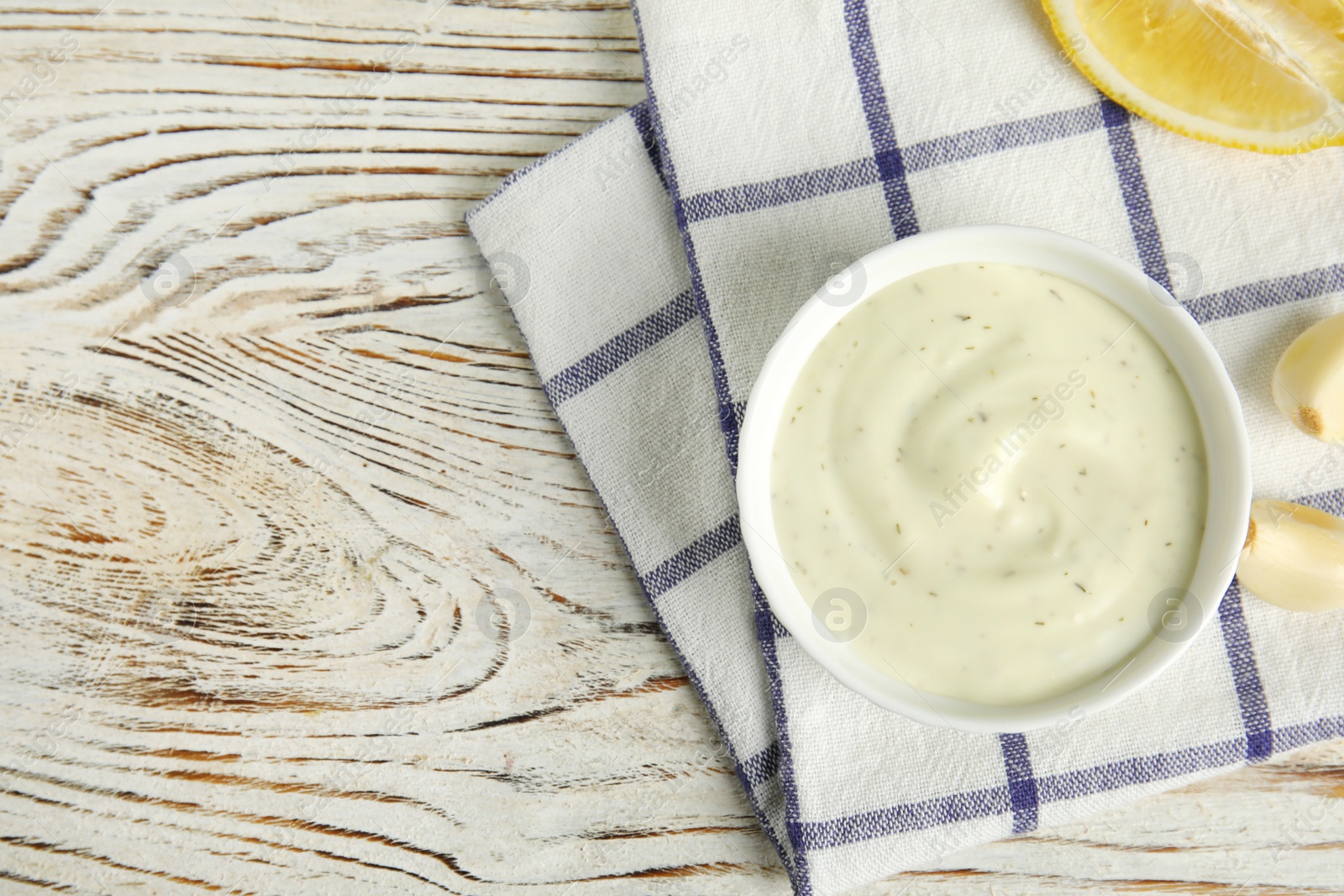 Photo of Flat lay composition with garlic sauce on wooden background. Space for text