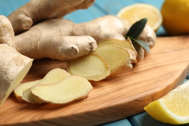 Photo of Cut ginger and lemon on wooden board, closeup