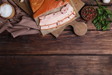 Photo of Flat lay composition with delicious smoked bacon on wooden table, space for text