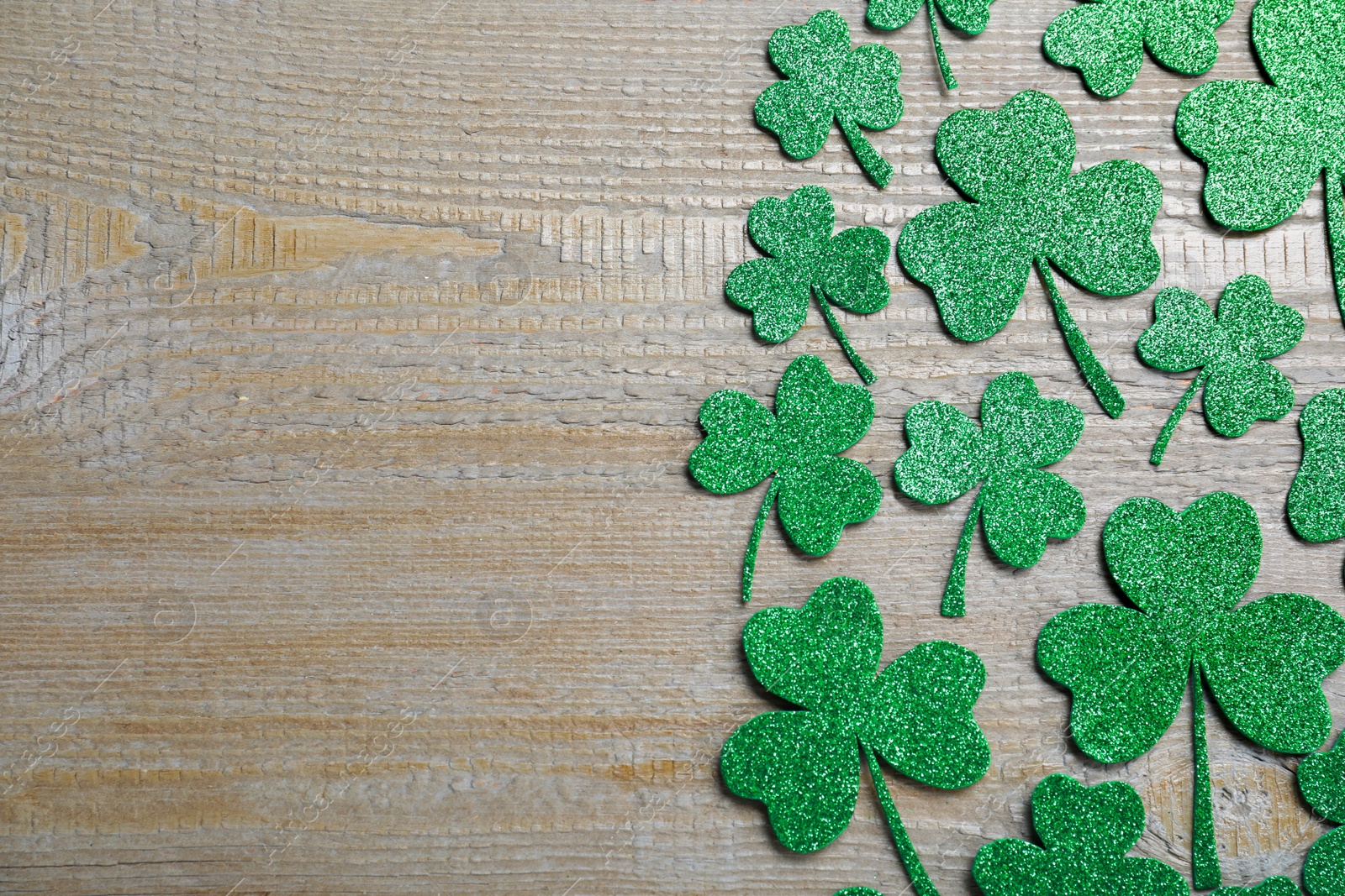 Photo of Flat lay composition with clover leaves on wooden table, space for text. St. Patrick's Day celebration