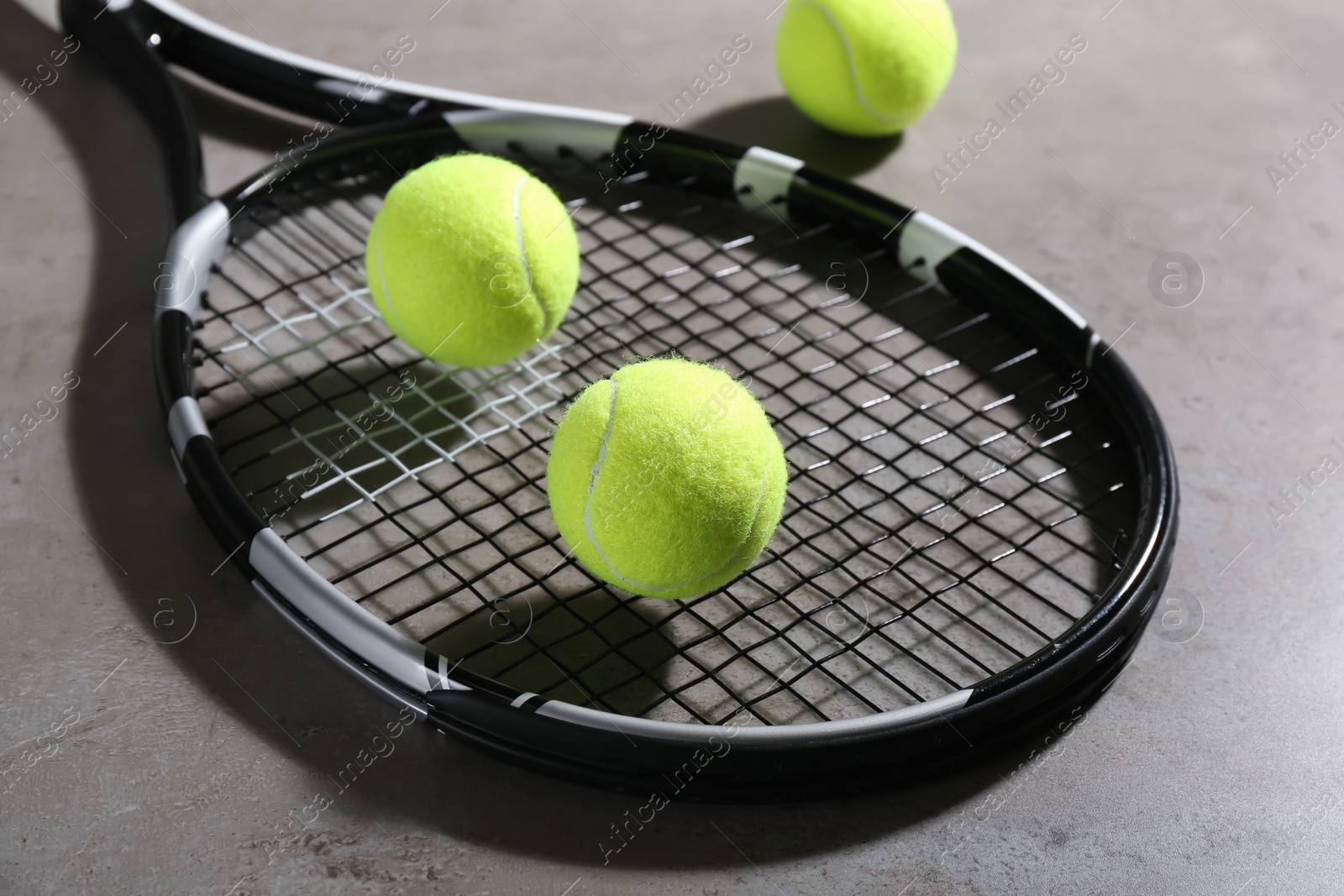 Photo of Tennis racket and balls on grey table. Sports equipment