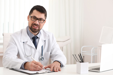 Photo of Portrait of male doctor in white coat at workplace