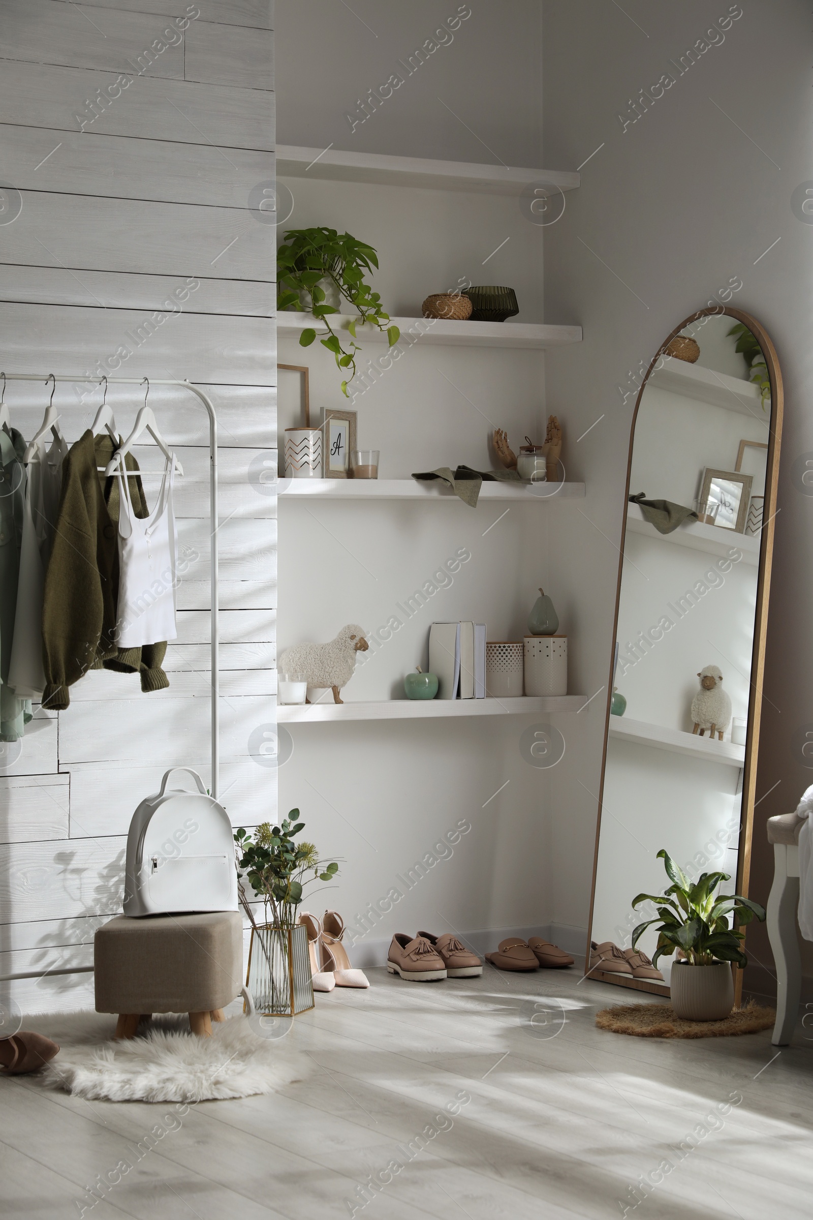 Photo of Rack with different stylish clothes, shoes and decorative elements in dressing room. Interior design