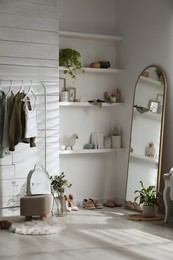 Rack with different stylish clothes, shoes and decorative elements in dressing room. Interior design