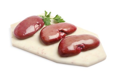 Photo of Board with fresh raw pork kidneys and parsley on white background