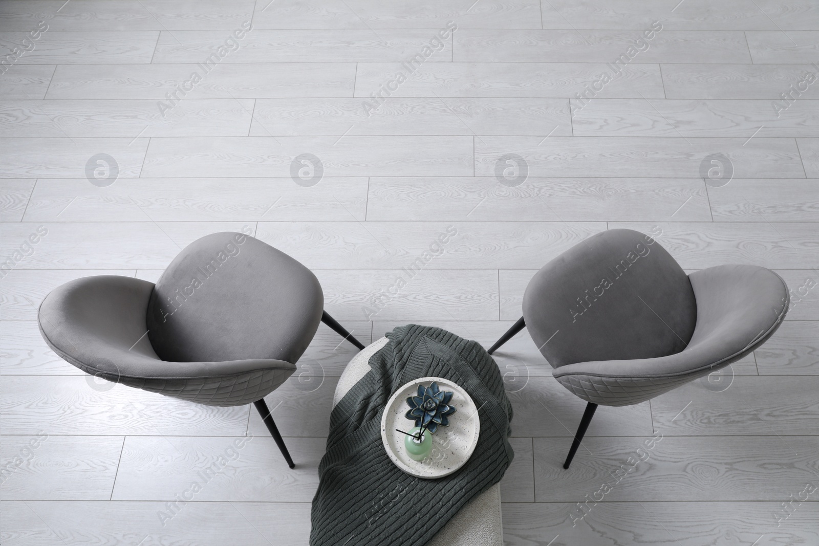 Photo of Stylish grey chairs and pouf with decor in room, top view. Interior design