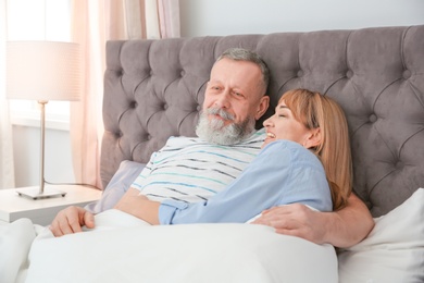 Mature couple together in bed at home