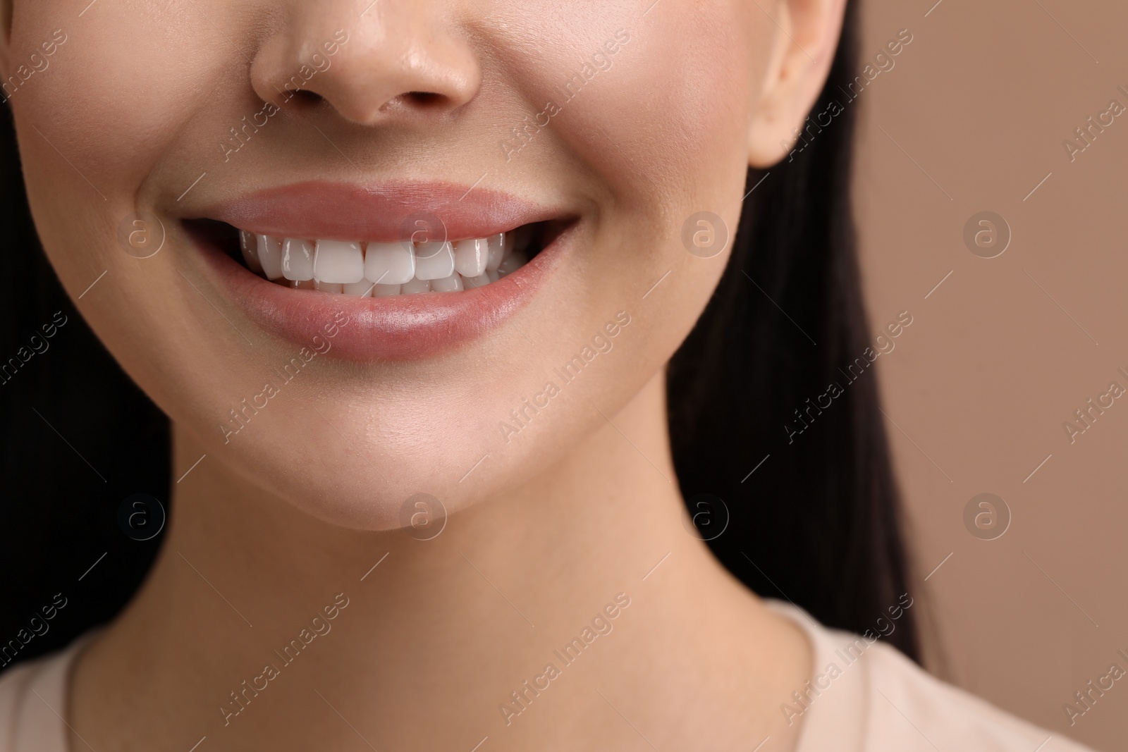 Photo of Woman with clean teeth smiling on beige background, closeup