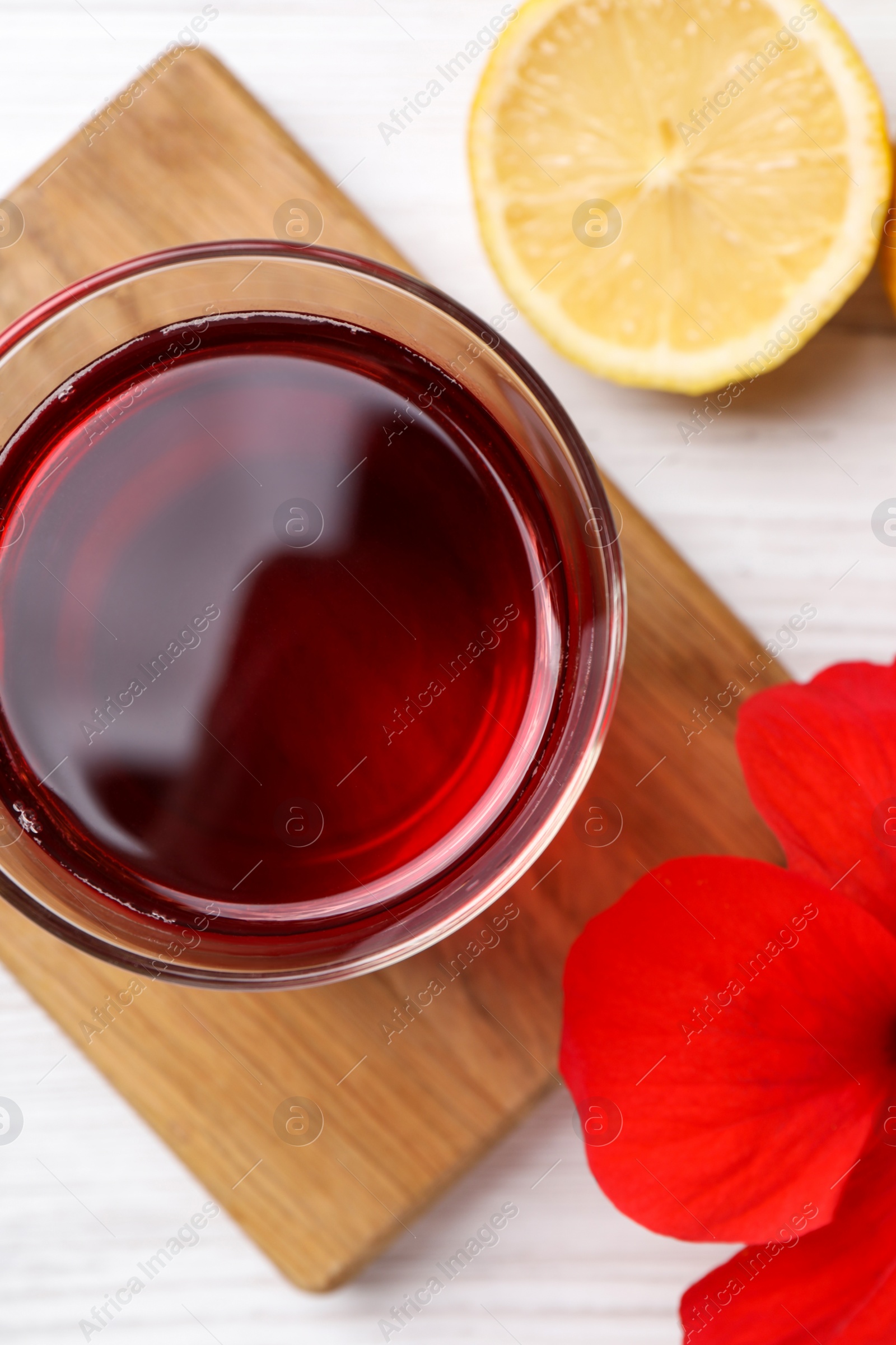 Photo of Delicious hibiscus tea, lemon and beautiful flower on white wooden table, flat lay