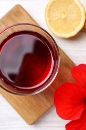 Photo of Delicious hibiscus tea, lemon and beautiful flower on white wooden table, flat lay