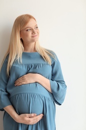 Portrait of beautiful pregnant woman on light background