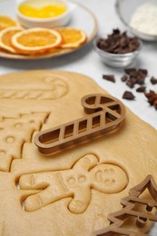 Photo of Christmas treat. Cookie cutters and dough on table, closeup