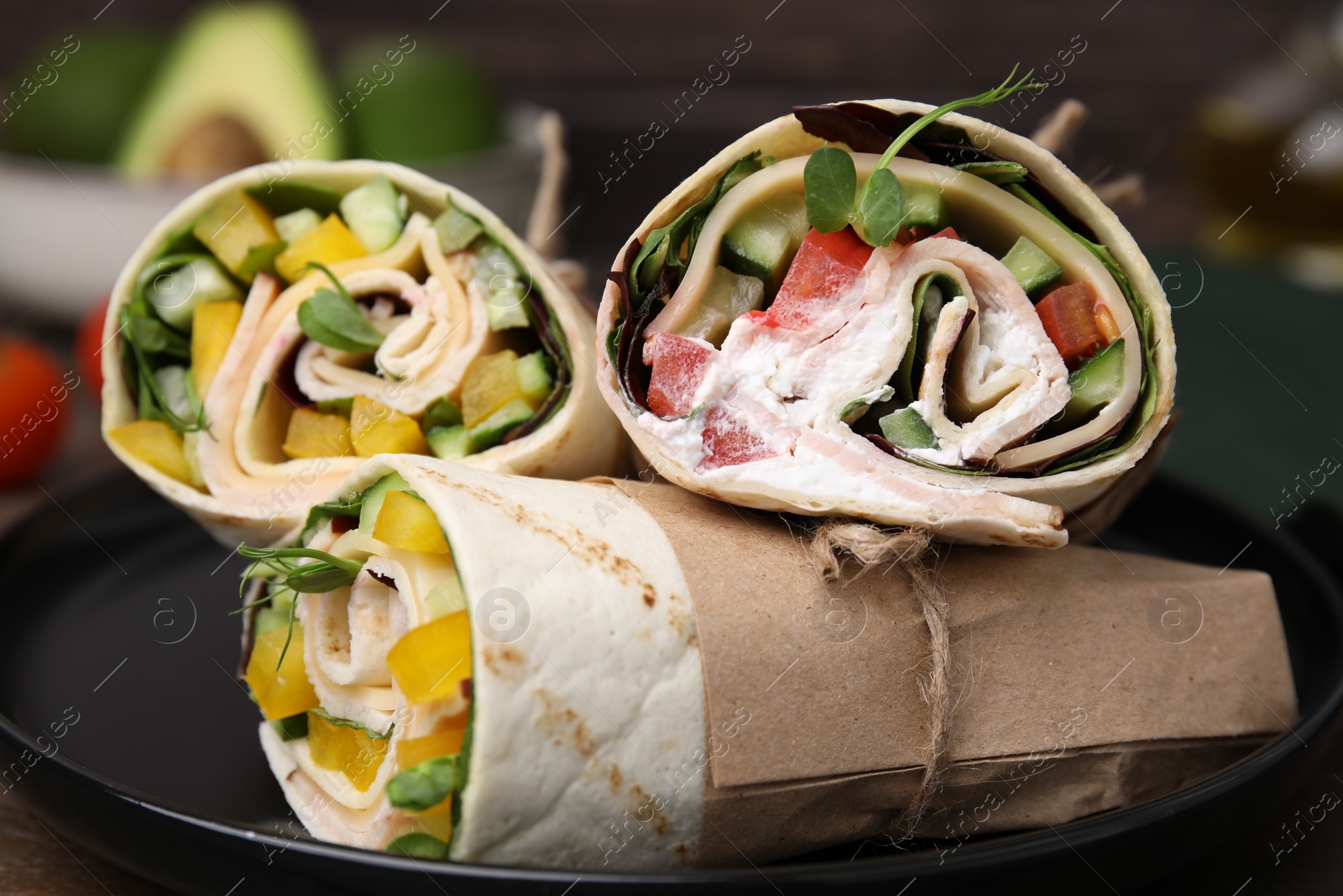 Photo of Delicious sandwich wraps with fresh vegetables on plate, closeup