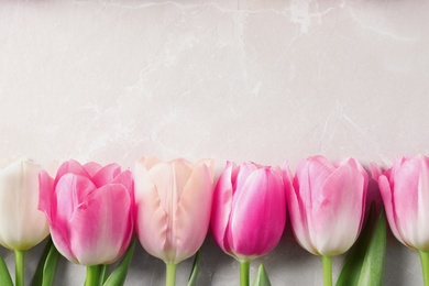 Photo of Flat lay composition of beautiful tulips  on marble background, space for text. International Women's Day