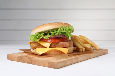 Photo of Delicious tofu burger served with french fries on white table