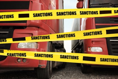 Image of Economic sanctions. Trucks on road in front of barrier tape