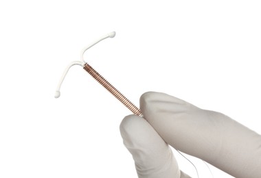 Photo of Gynecologist holding copper intrauterine contraceptive device on white background, closeup