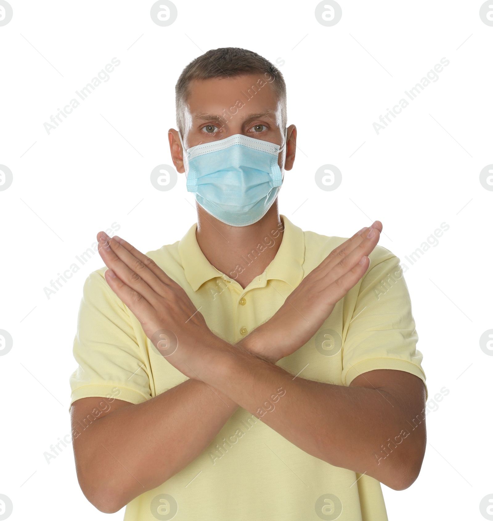 Photo of Man in protective mask showing stop gesture on white background. Prevent spreading of coronavirus