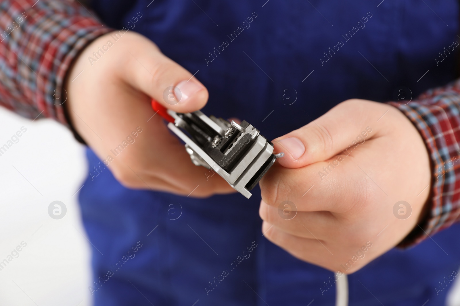 Photo of Professional electrician stripping wiring on white background, closeup