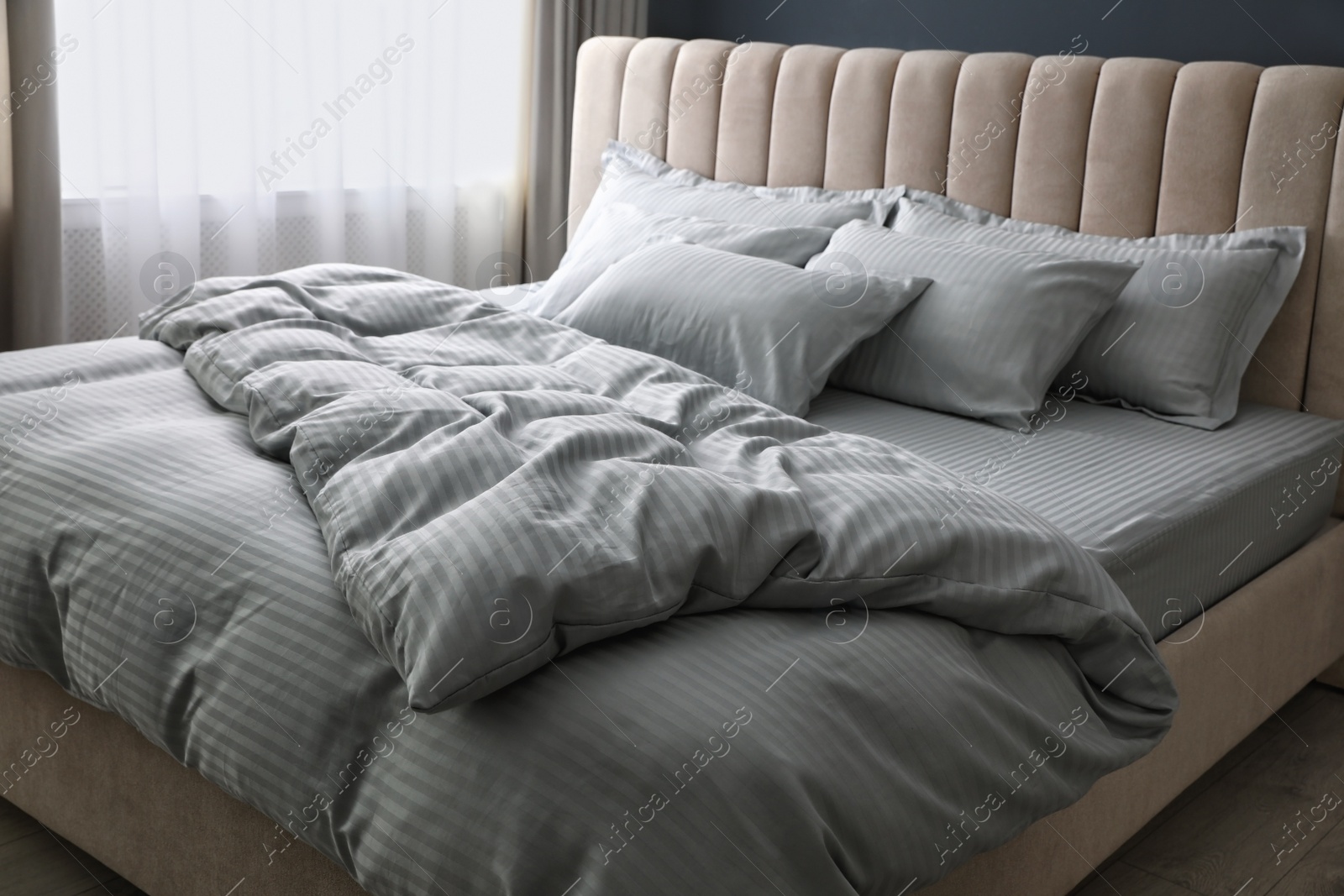 Photo of Comfortable bed with soft blanket and pillows indoors