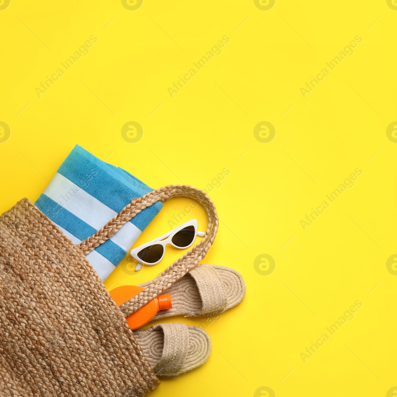 Photo of Beach accessories on yellow background, flat lay. Space for text