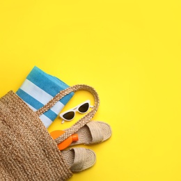 Photo of Beach accessories on yellow background, flat lay. Space for text