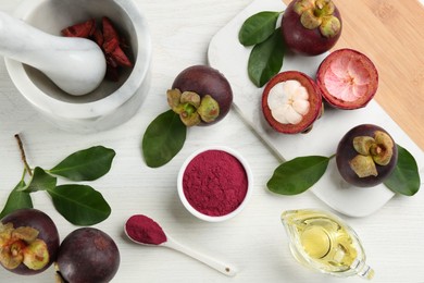 Flat lay composition with purple mangosteen powder on white wooden table