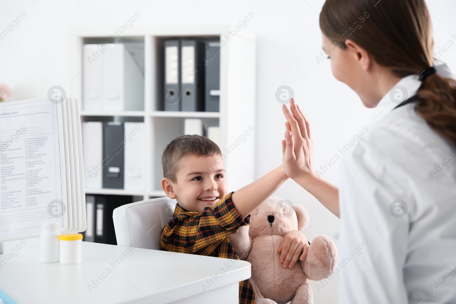 Photo of Children's doctor working with little patient in clinic