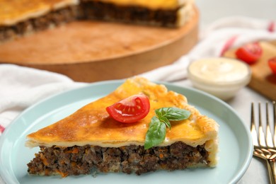 Photo of Piece of delicious pie with minced meat, tomato and basil served on table, closeup