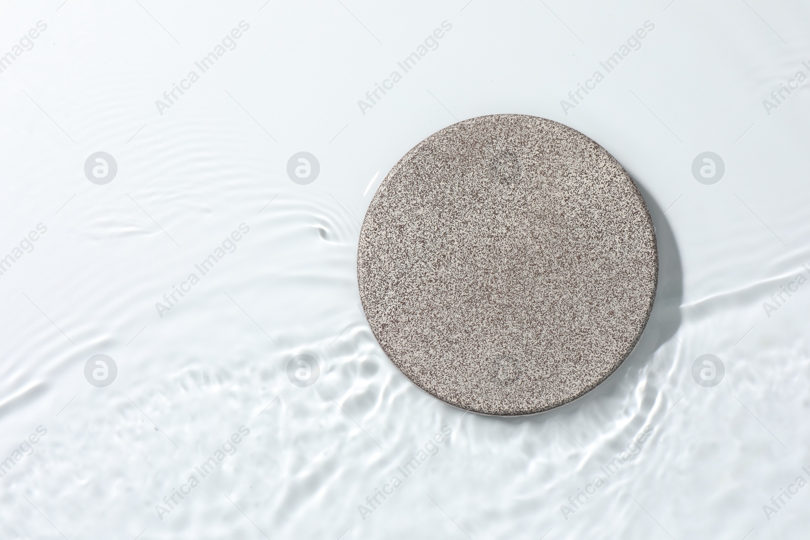 Photo of Presentation for product. Stone podium in water on white background, top view