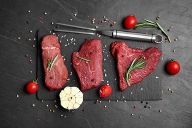 Photo of Fresh raw meat steaks and spices on black table, flat lay