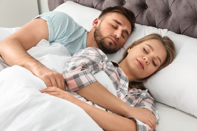 Photo of Young couple sleeping together in bed at home