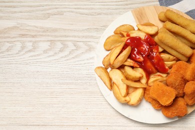 Photo of Different snacks with tasty ketchup on wooden table, flat lay. Space for text