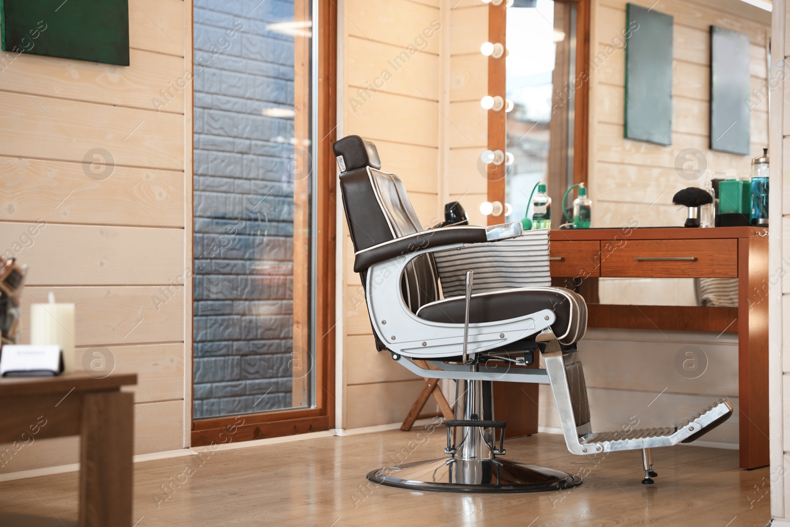 Photo of Stylish hairdresser's workplace with professional armchair in barbershop