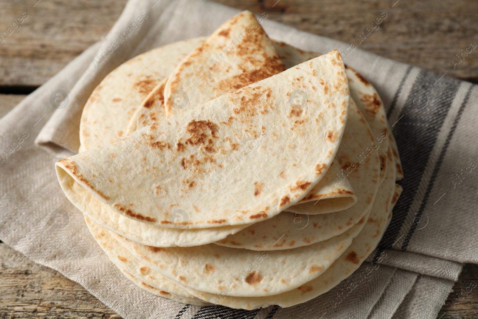 Photo of Tasty homemade tortillas on wooden table, closeup