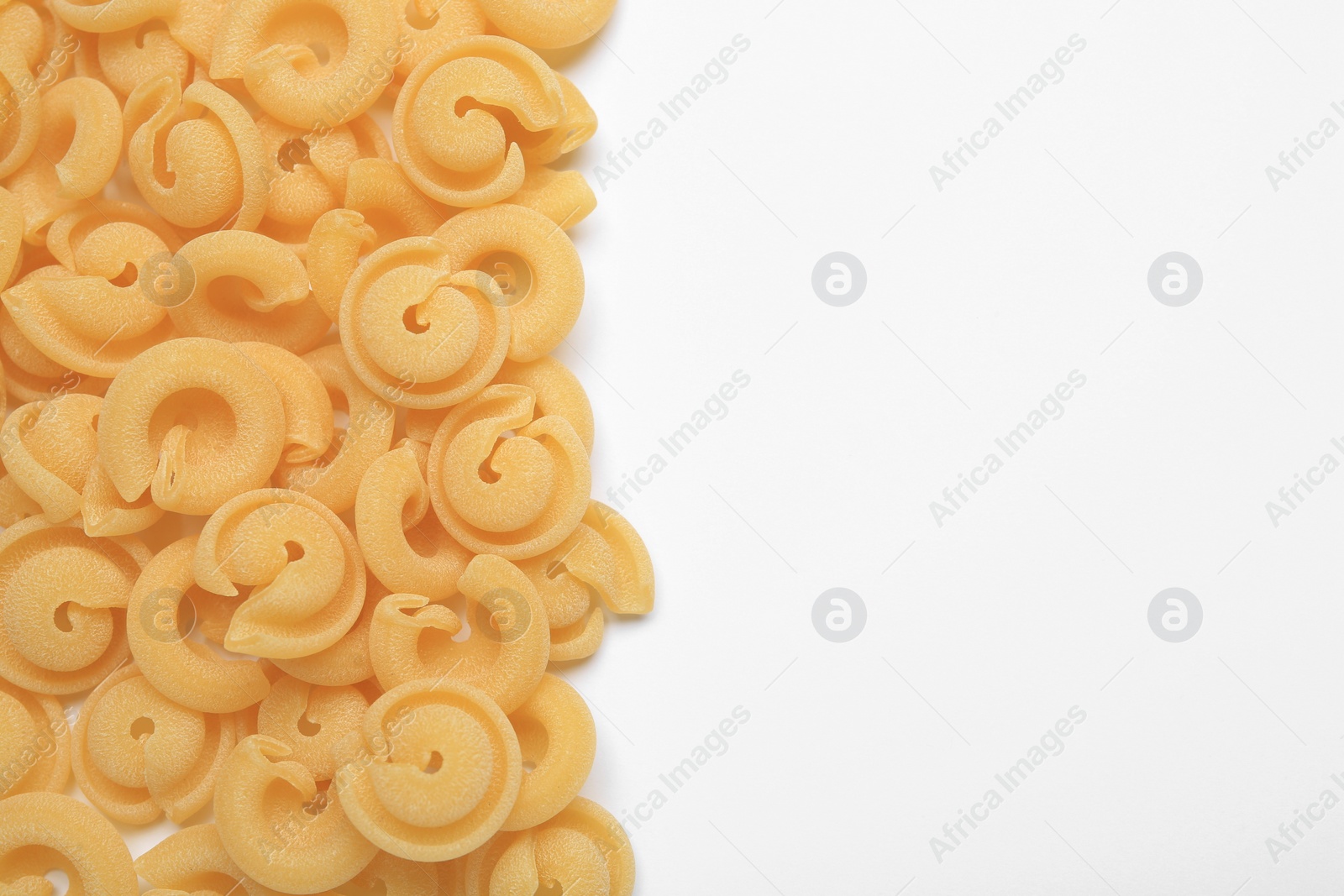 Photo of Raw dischi volanti pasta on white background, top view. Space for text