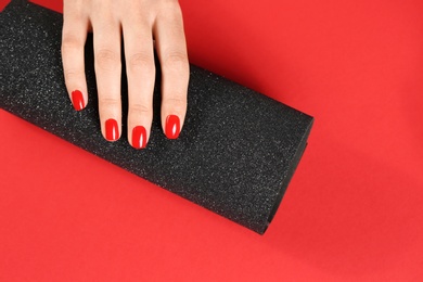 Photo of Woman showing manicured hand with red nail polish on color background, top view. Space for text