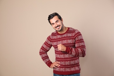 Photo of Portrait of happy man in Christmas sweater on beige background