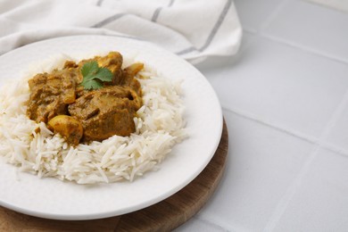 Photo of Delicious chicken curry with rice on white tiled table, closeup