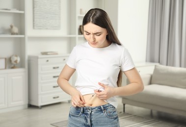 Diabetes. Woman making insulin injection into her belly at home