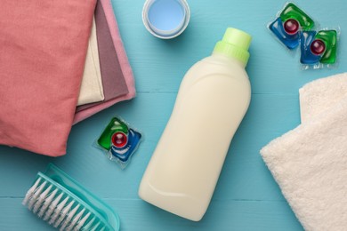 Photo of Flat lay composition with bottle of fabric softener on light blue wooden table