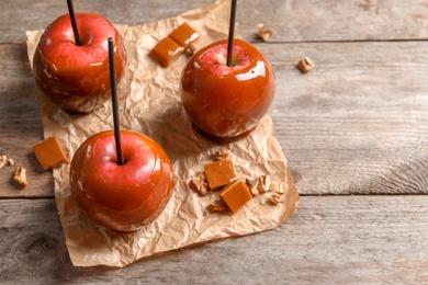 Photo of Delicious red caramel apples on table