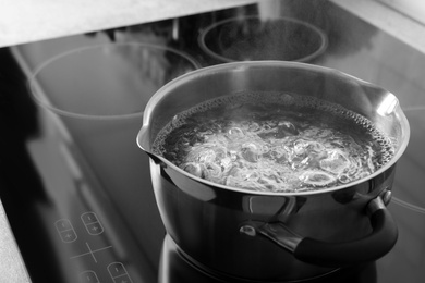 Photo of Pot with boiling water on electric stove, space for text