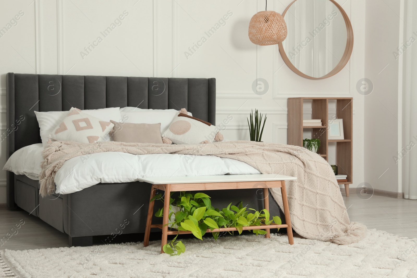 Photo of Stylish bedroom interior with large comfortable bed and mirror