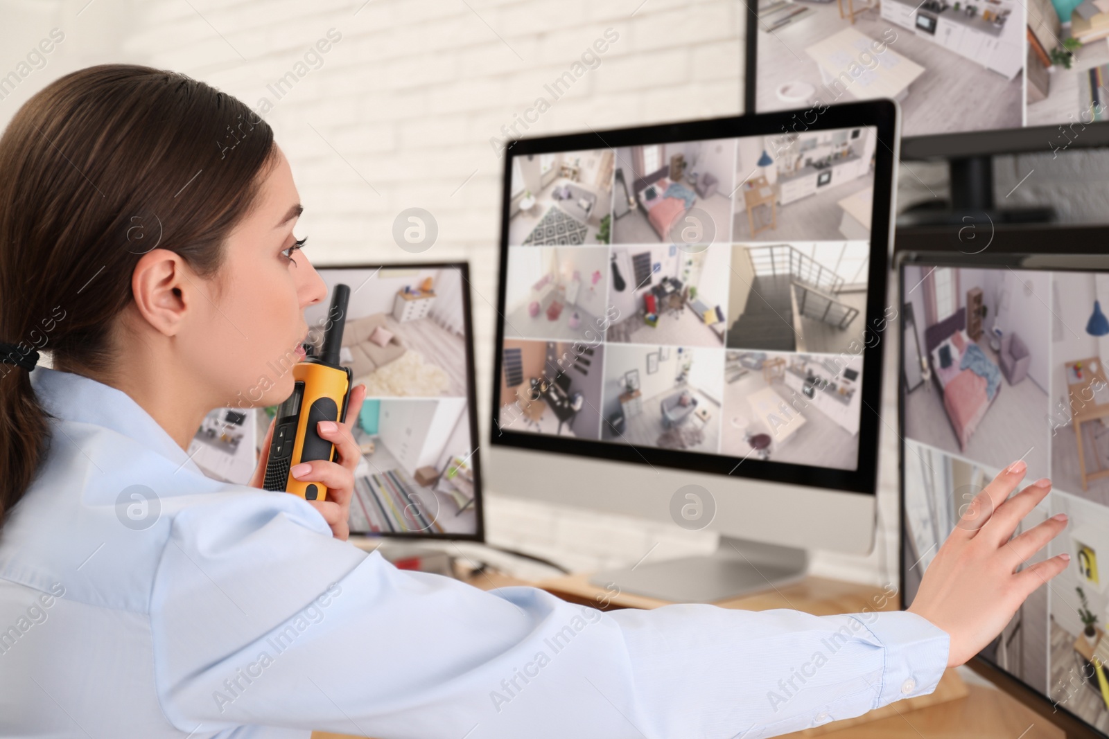 Photo of Female security guard with portable transmitter at workplace