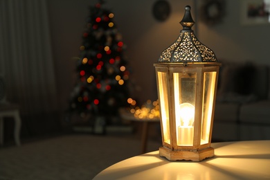 Beautiful decorative lantern and Christmas tree in dark room