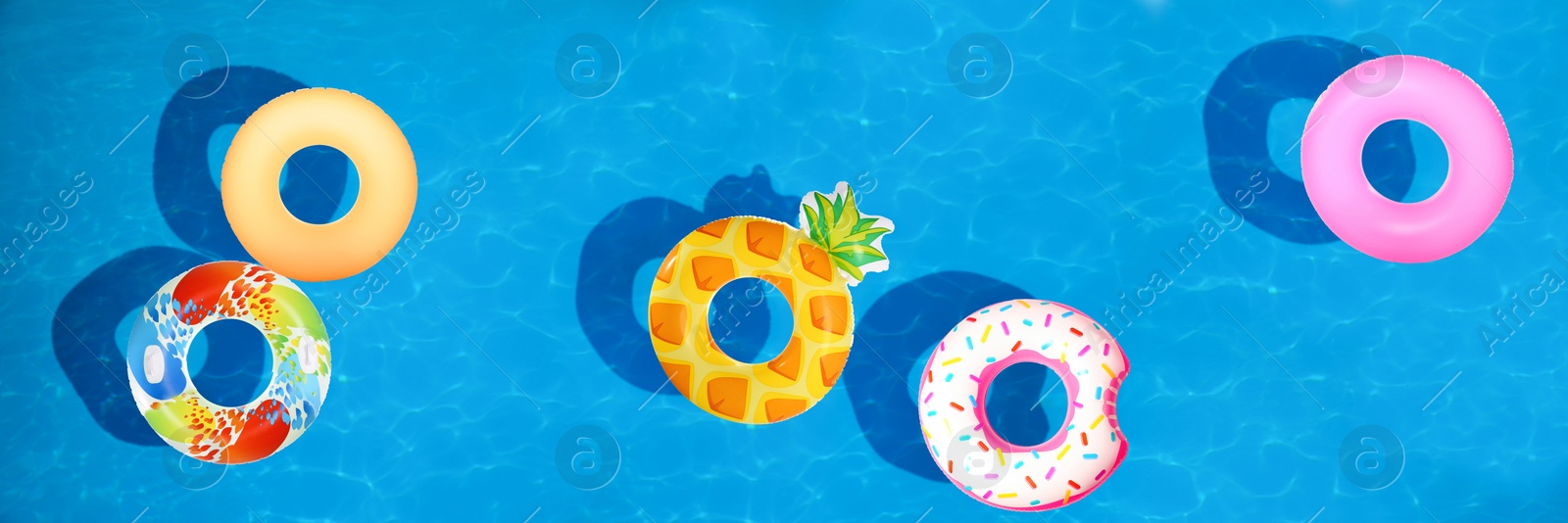 Image of Different inflatable rings floating in swimming pool, top view. Banner design