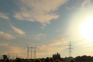 Photo of Telephone poles with cables on sunny day outdoors