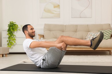 Man doing morning exercise on fitness mat at home