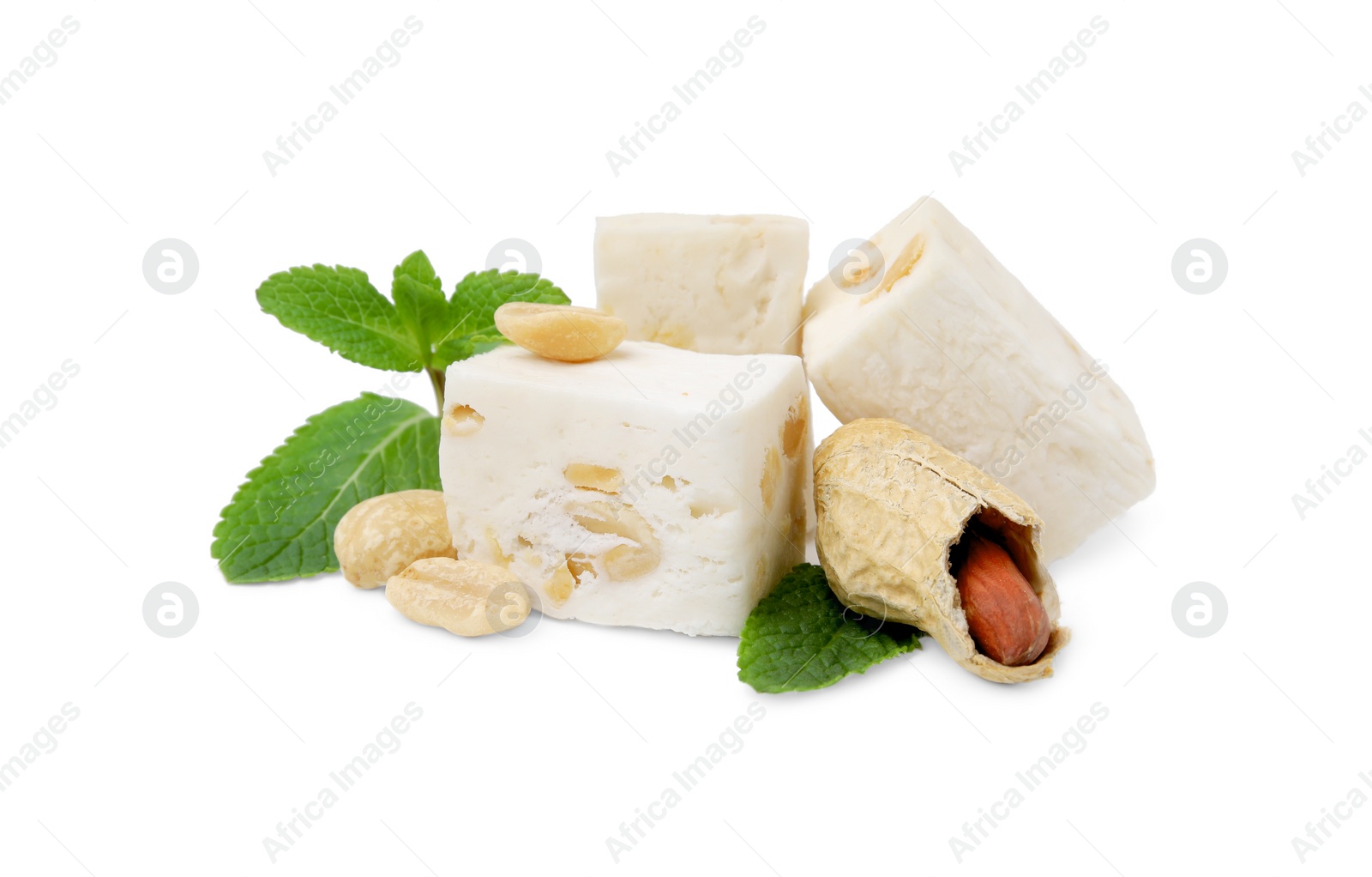 Photo of Pieces of delicious nougat, peanuts and mint on white background